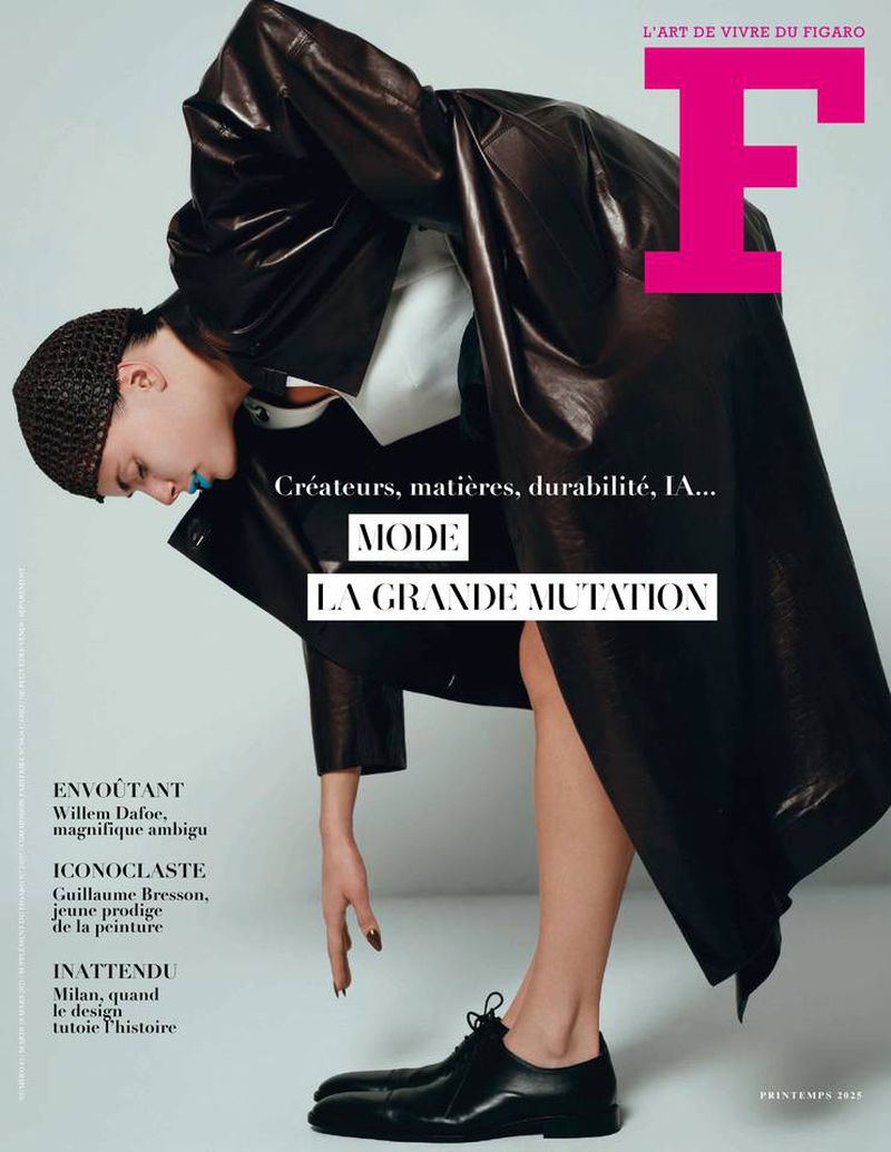 Fashion magazine cover featuring a person in a dark coat and black dress shoes, with the magazine's logo and various text elements.