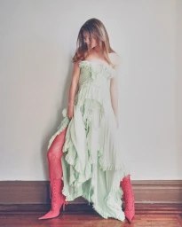 Model in pale green ruffled dress and pink boots standing against a neutral wall for Harper's Bazaar Thailand project Pillow Talk.
