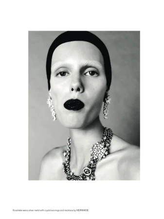 Striking black-and-white beauty shot of a woman with black lipstick, large crystal jewelry, a headband, and fair skin in a studio.