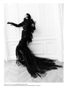 Model in black tulle dress leaning against a white panelled wall by photographer Robin Galiegue for Beyond Noise.