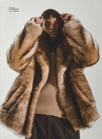 Model in brown faux fur coat adjusting dark sunglasses against a plain off-white studio background for GQ Mexico editorial