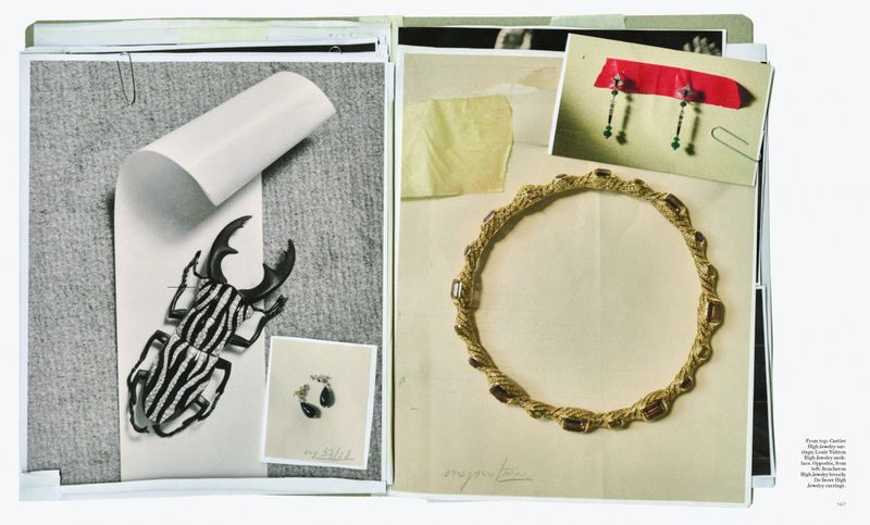Collage of paper cutouts and jewelry, featuring a beetle design and a gold necklace with red stones, creating an artistic still life composition.