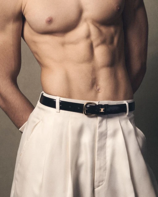 Torso shot of a shirtless male model with defined abdominal muscles wearing white dress pants and a black belt with a gold buckle.
