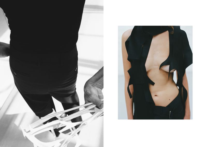 Fashion editorial featuring a bare-chested woman in black attire and a person holding a white sculpture in a stark indoor setting.