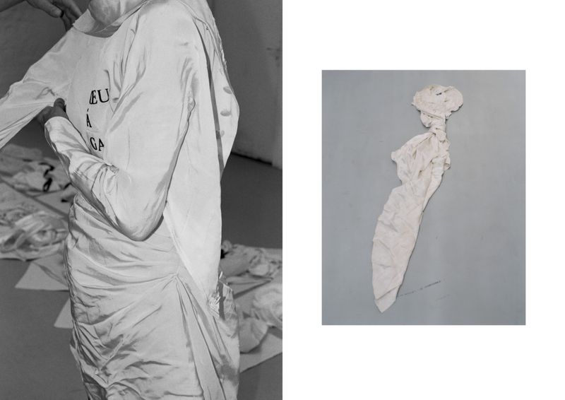 Fashion photography featuring a model being dressed in a white dress with text, accompanied by a crumbled dress on a gray background.