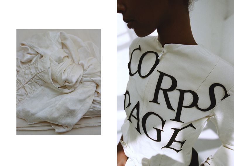 Fashion shot of a black model wearing an avant-garde white dress with black graphic text. The shot highlights unique design and styling.