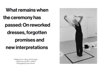 Black and white editorial image of a model holding sheer fabric overhead inside a minimalist studio space.