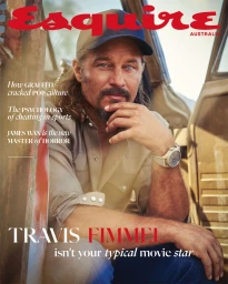 Actor Travis Fimmel wearing a cap and button-down shirt inside a rustic vehicle for an Esquire magazine cover portrait
