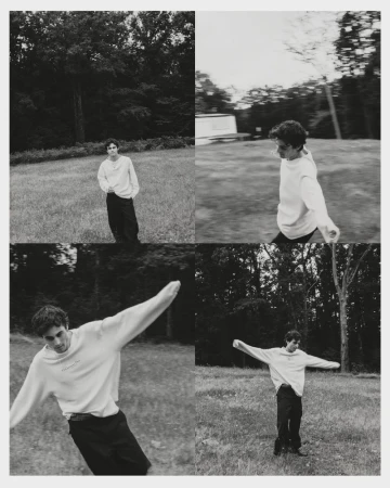 Monochrome four-panel editorial grid of Julien de Saint Jean moving playfully across a grassy field in a white sweater and black trousers.