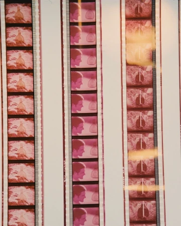 Film strips show vintage images of a man's profile and an object resembling a bottle with light orange and pink color grading.