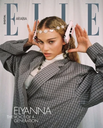 Elle Arabia magazine cover featuring Elyanna wearing a grey blazer, a coin headpiece with pink toy cars, and coin necklace.