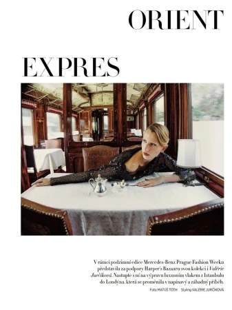 Fashion shot inside Orient Express train car: blond model poses at table with tea service, dark sequined top, editorial, travel.