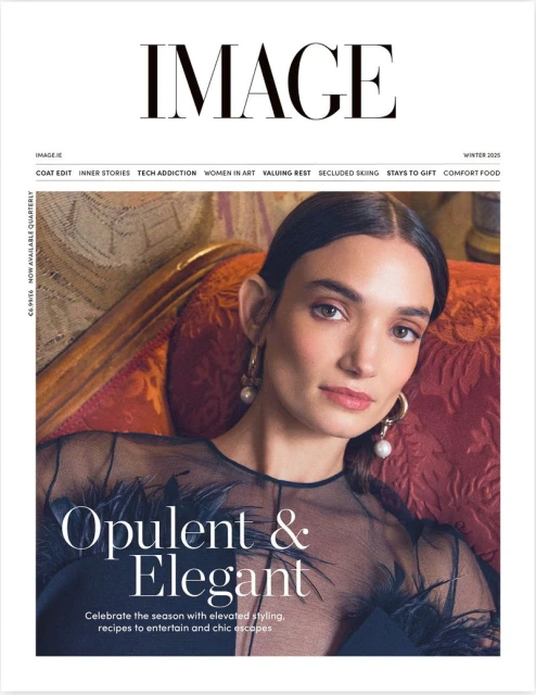 Magazine cover featuring a woman with pearl earrings and a sheer black top in front of a dark red chair and the masthead IMAGE.