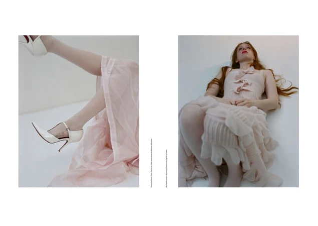 Fashion editorial features a red-haired woman in a pink dress, posing gracefully with white high heels in a bright indoor studio setting.