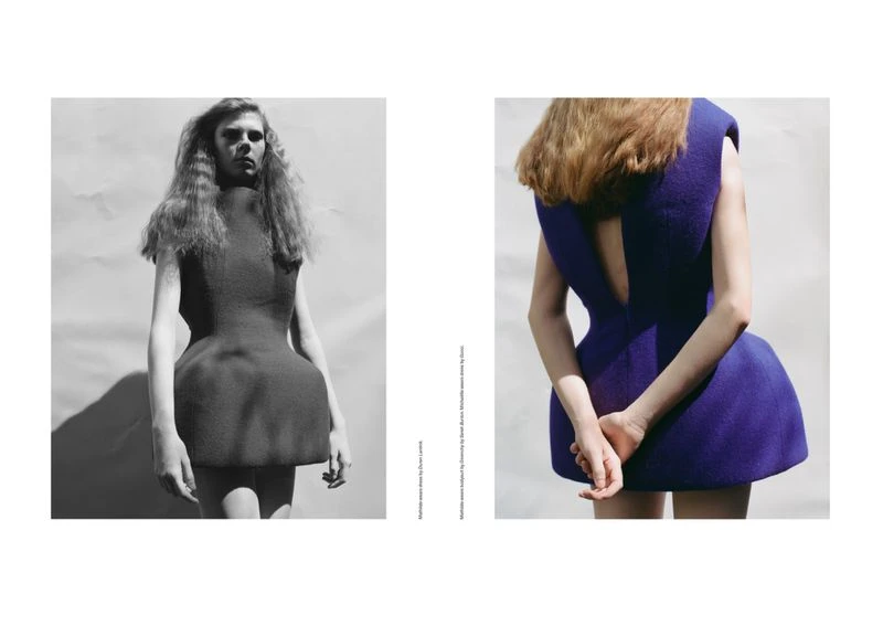 Editorial fashion shot of two women modeling minimalist dresses, one in black and white and the other in cobalt blue, in a studio setting.
