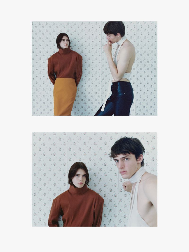 Two slender fashion models pose in split-screen view, one in a brown turtleneck and mustard skirt, the other shirtless with a white sash.