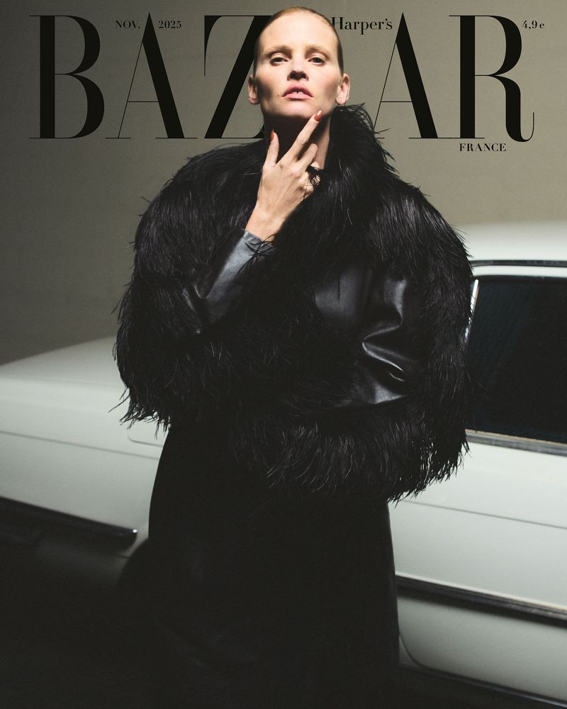 Bazaar France cover featuring a woman in a black jacket with feathered trim posing in front of a classic white car, November 2023.