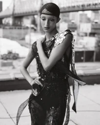 Monochrome fashion editorial portrait of model Anok Yai in an embellished dress on a rooftop by Ethan James Green for British Vogue.