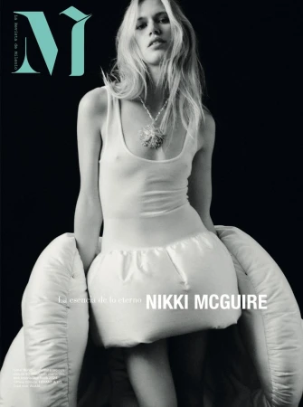 Magazine cover featuring a young female fashion model with long blonde hair wearing a white outfit, set against a black background.