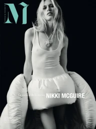 Model wearing a white tank top and sculptural skirt against a dark background for M Revista de Milenio
