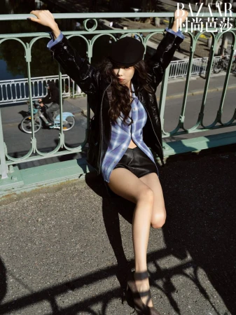 Woman in black leather jacket and newsboy cap posing on a bridge for Where Paris Whispers editorial by Harper's Bazaar China.