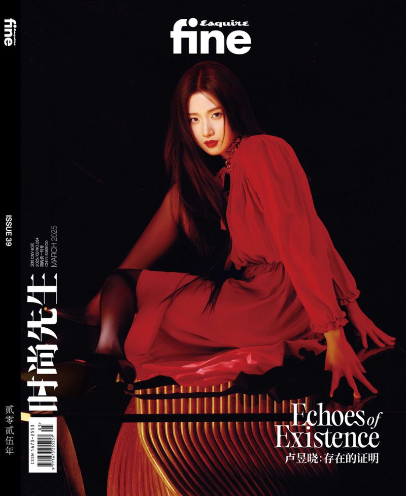 Woman wearing a vibrant red dress seated on a reflective dark surface against a black background for Esquire China magazine cover.