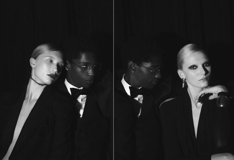 Monochrome portrait of two fashionably dressed adults, an African-American male in a tuxedo and a Caucasian female with dark eye makeup.