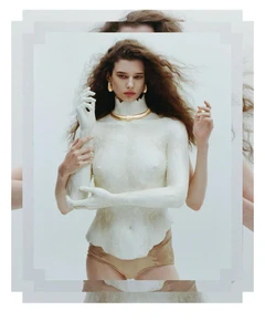 Model wearing gold necklace and earrings with white sculpted upper body against a plain background for Harper's Bazaar Italia