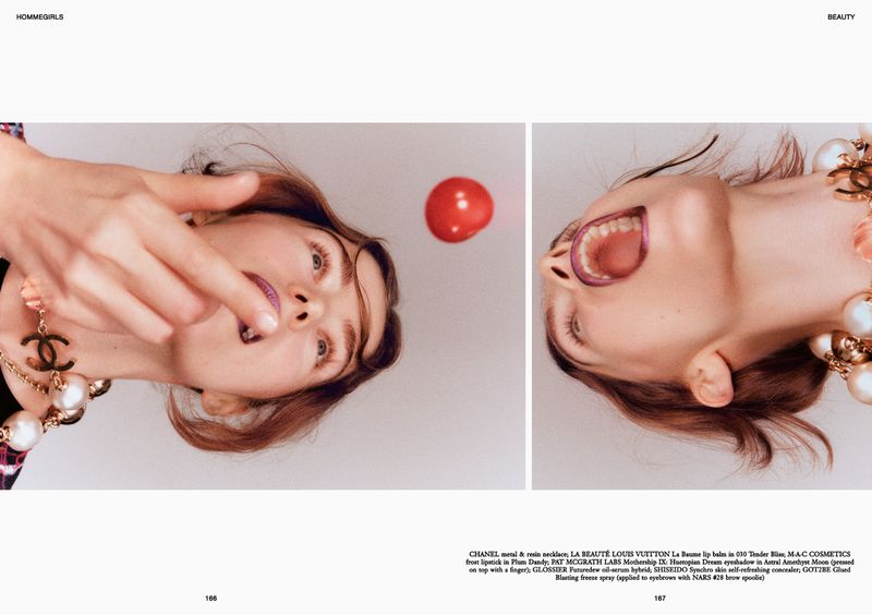 Beauty editorial featuring an adult female with plum lipstick and statement necklace, indoor studio setting, overhead angle.
