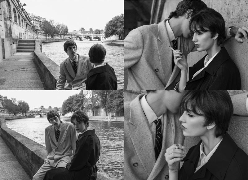 Black and white fashion shot featuring a stylish couple smoking outdoors near a waterway in a European city, exuding a classic, vintage aesthetic.