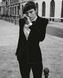 Model wearing a black velvet suit jacket and beret posing on a city street for Telegraph Luxury