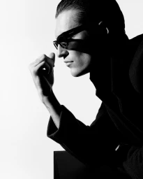 Black and white profile portrait of model Myles Crosby wearing dark sunglasses and a coat for Zara Night A/W 25.