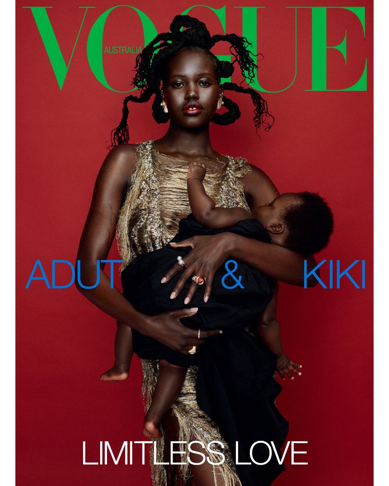 Vogue Australia magazine cover featuring Adut Akech, an adult female, holding a baby against a red background, with Vogue logo.
