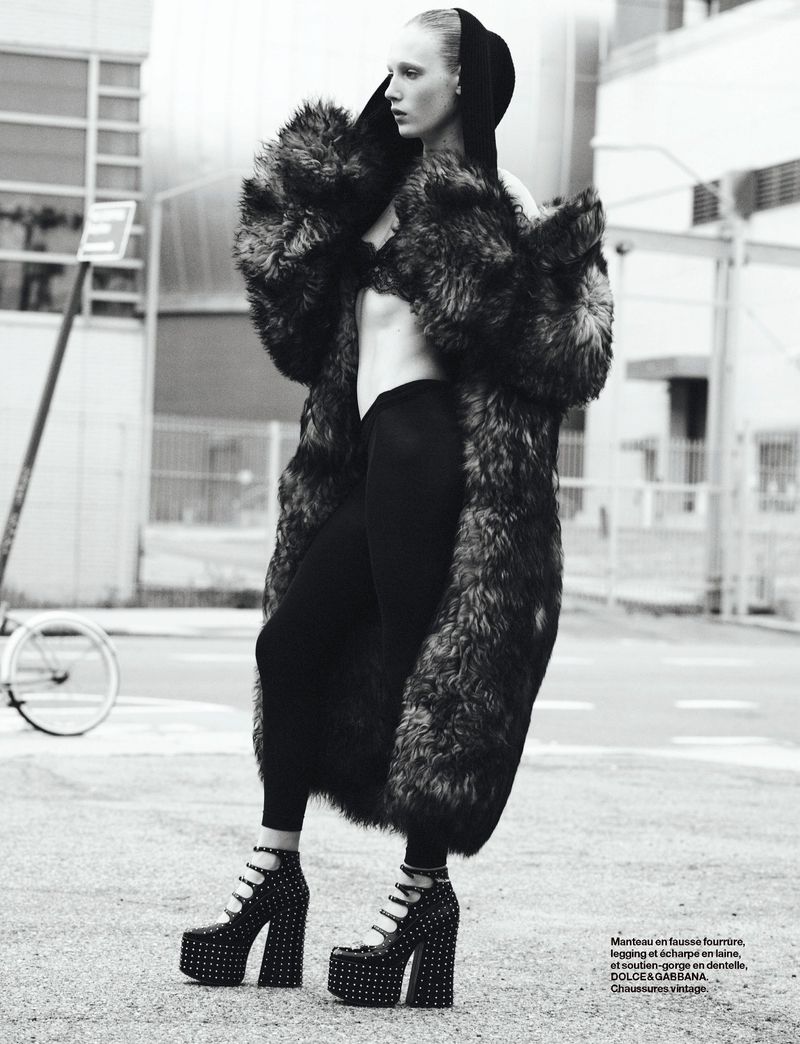 Model in fluffy faux fur coat and platform heels standing on a street for Numero France