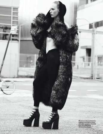 Model in fluffy faux fur coat and platform heels standing on a street for Numero France