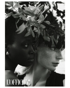 Close-up black and white portrait of two models wearing elaborate feather headpieces for L'Officiel Baltics.