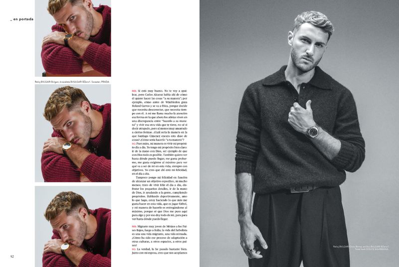 Studio shot of a stylish blond male model in a sweater, looking at the camera, wearing a wrist watch, against a neutral background.