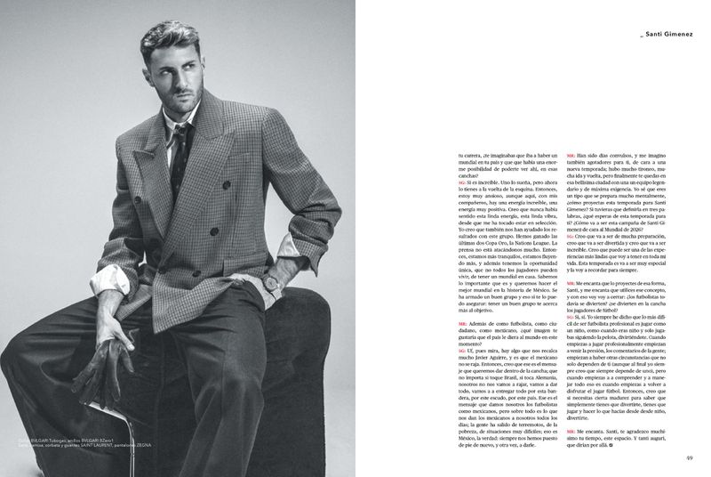 Santi Gimenez seated in a tailored double-breasted blazer and tie for a monochrome magazine editorial feature.