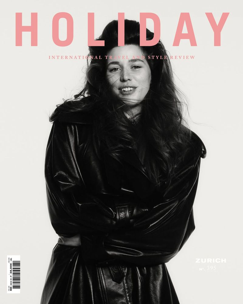 Holiday Magazine cover featuring a woman in a black coat and hat against a light background, with pink lettering.
