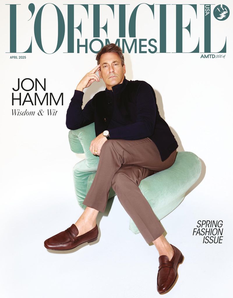 L'Officiel Hommes cover featuring Jon Hamm in a chair, wearing brown trousers and loafers, set against a plain background in a studio shot.