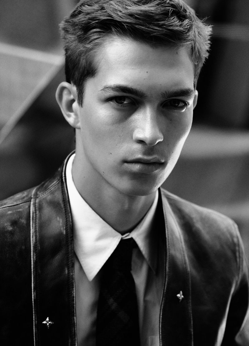 Black and white portrait of male model Just Verhoeff wearing a dark jacket, white shirt and tie for Numero Homme.