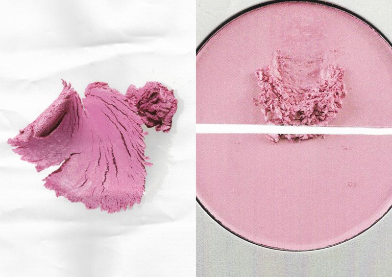 Close-up of pink cosmetic powder, partially loose and partially in a compact, on a white surface, showcasing beauty and makeup products.