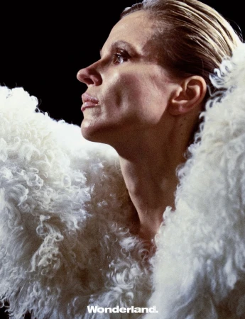 Model in textured white fluffy coat looking upward in profile against a dark background for Wonderland China