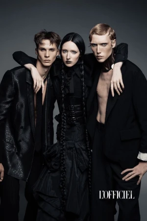 Three models posed in all-black gothic fashion against a dark grey studio background for L'Officiel Austria.