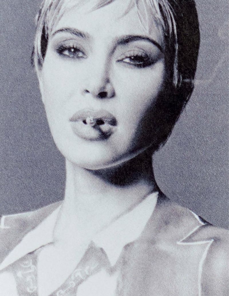 Close-up portrait of Kim Kardashian with short hair and a cigarette in her mouth, shot in monochrome grain for Re-Edition Magazine.
