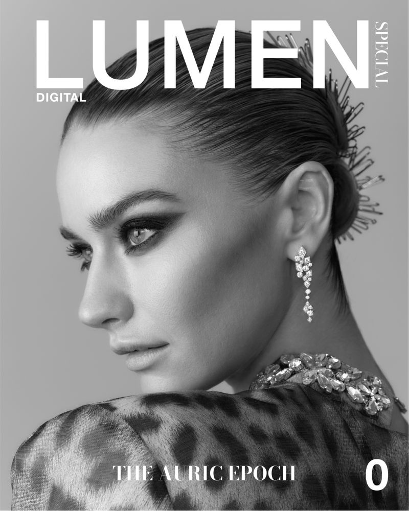 Black and white magazine cover featuring a model with dramatic eye makeup, jeweled hairpins, and a leopard print top, shot indoors.