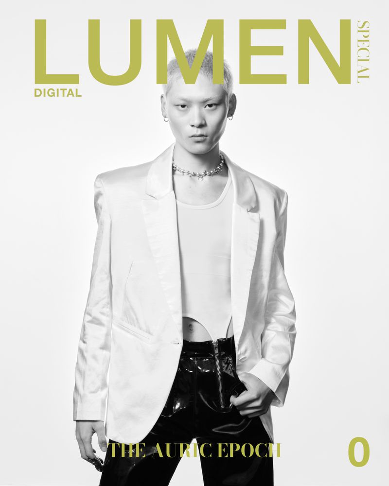 Fashion magazine cover featuring a model in a white blazer, matching top, and black pants, set against a clean, bright backdrop.