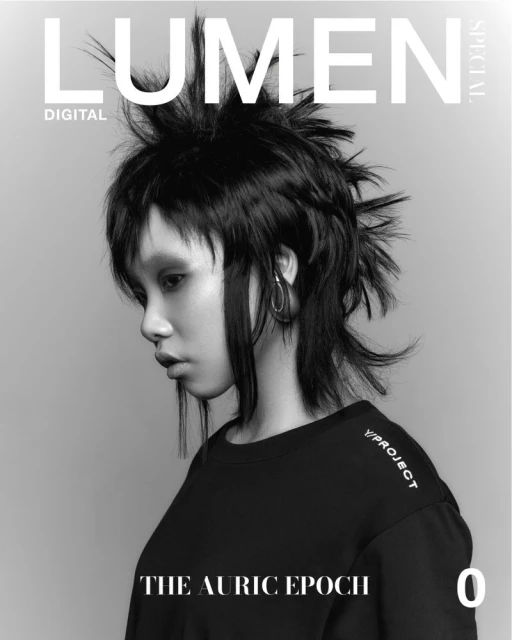 Magazine cover featuring an Asian woman with a spiky mullet hairstyle, hoop earrings, wearing a black top, against a gray background.