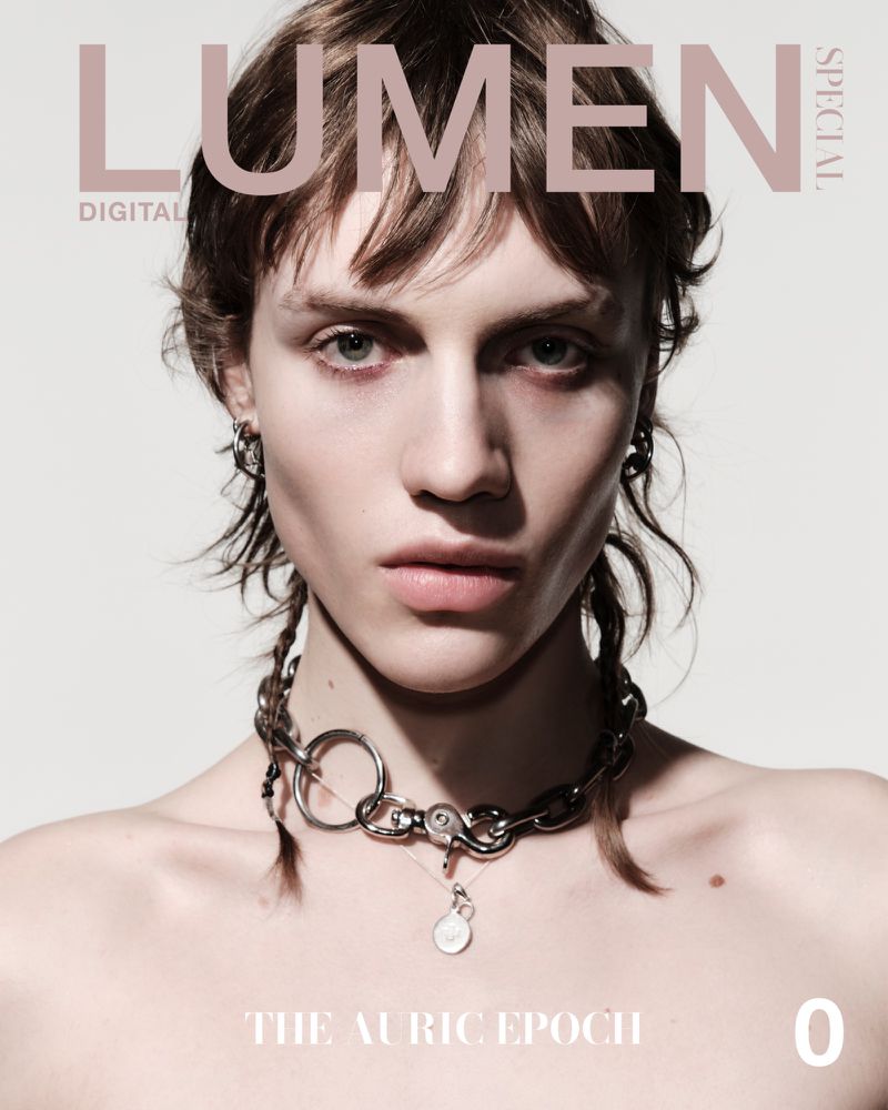 Close-up magazine cover featuring a bare-chested young adult looking directly at the camera, wearing a metal chain necklace.