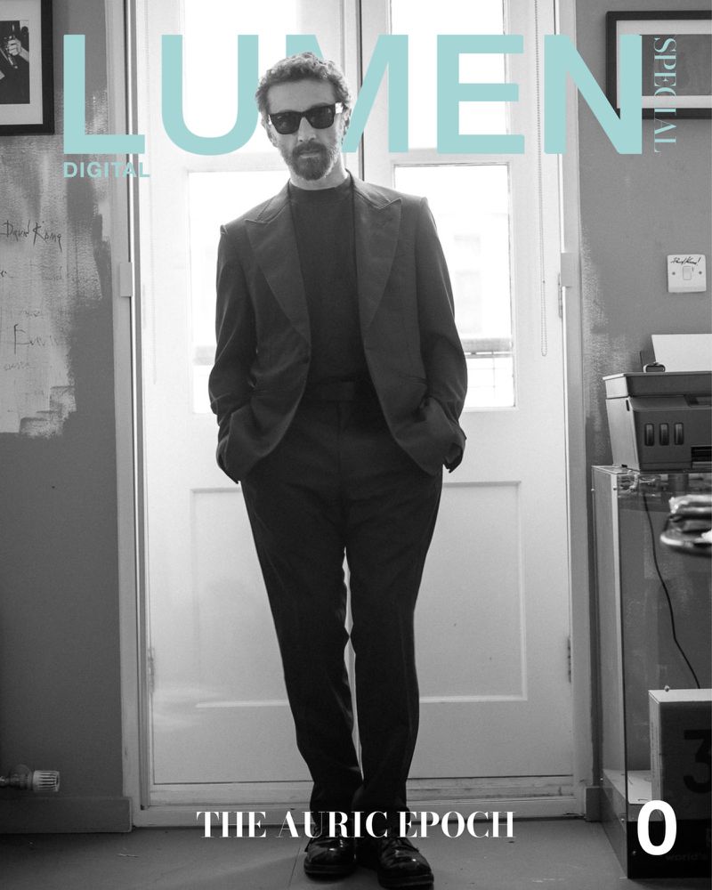 Magazine cover with a stylish man in a suit standing in a doorway, featuring bold 'Lumen' typography and monochrome design.